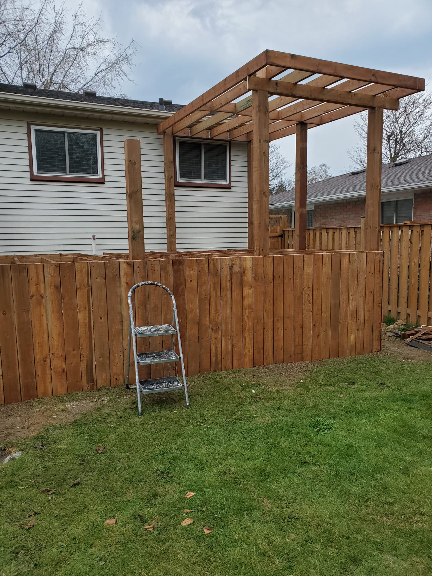 Backyard pergola structure with privacy wood fence
