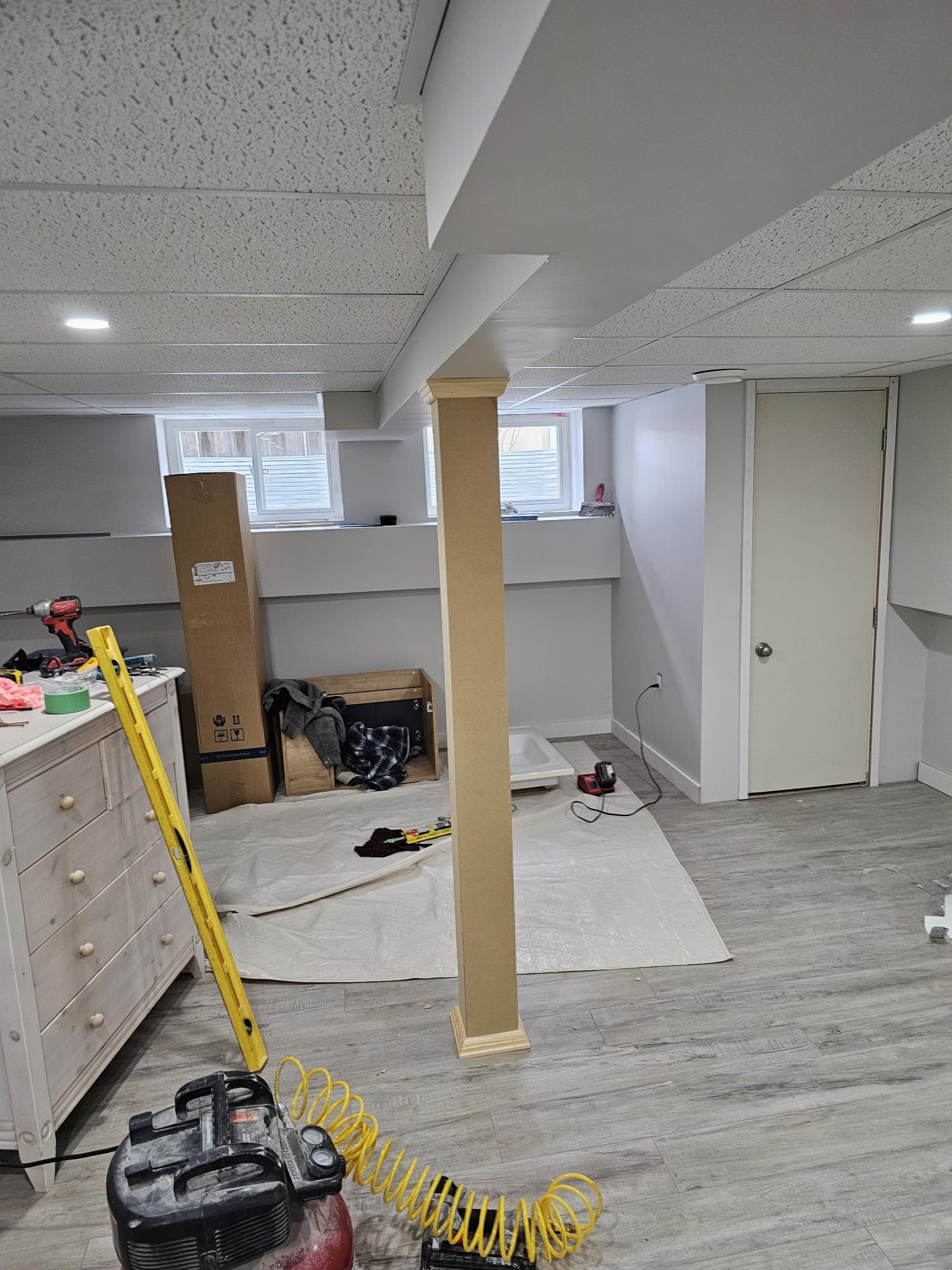 Finished basement with decorative column wraps and new flooring
