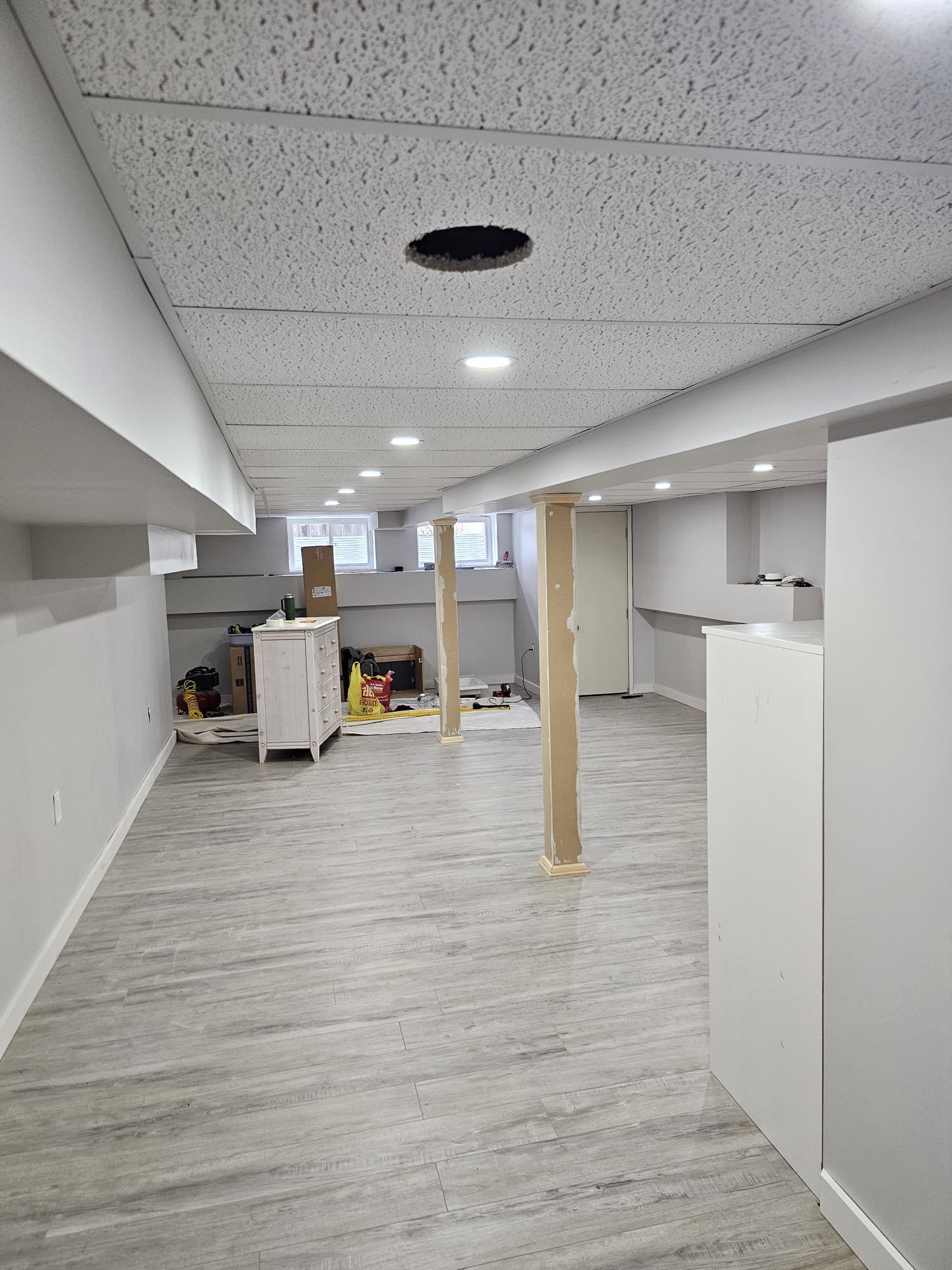 Finished basement with wrapped columns, LVP flooring and pot lights
