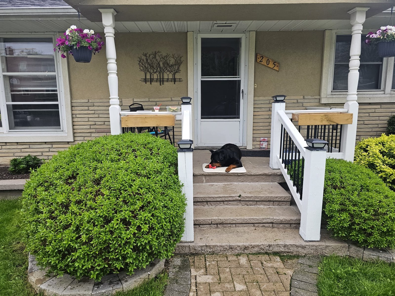 Front porch with decorative railing and stone steps