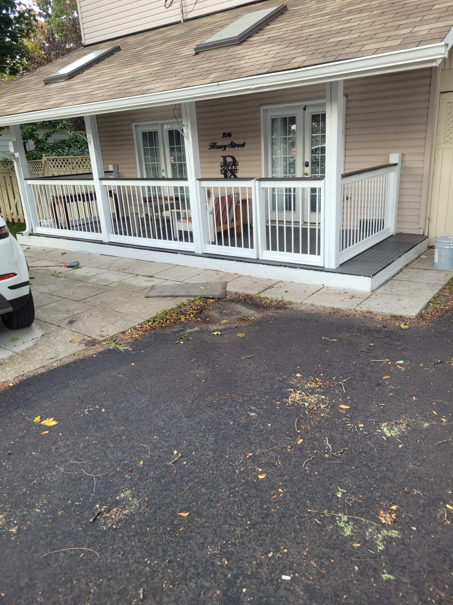 Front porch renovation with white railings and landscaping