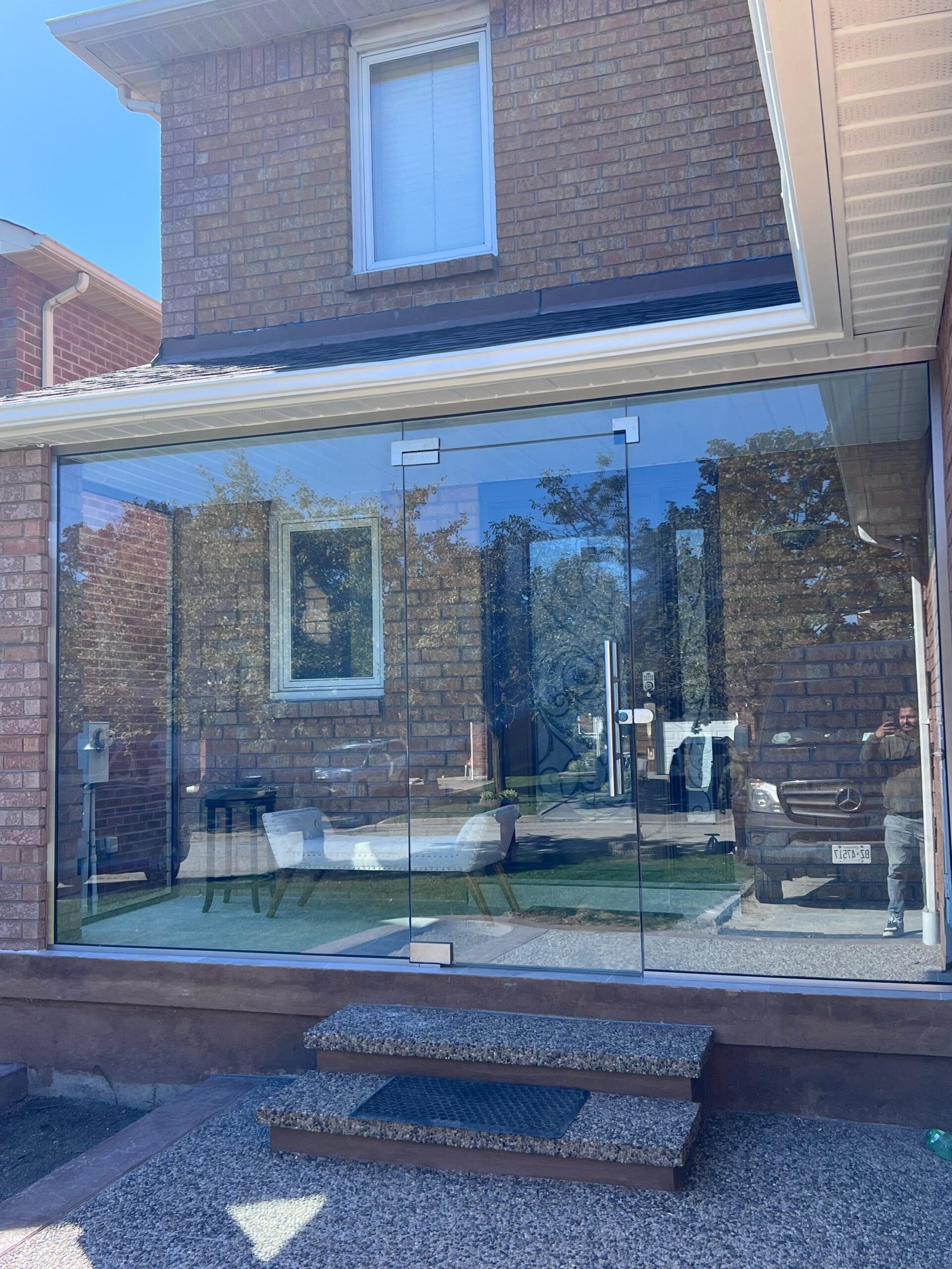 Custom glass sunroom addition on brick exterior home