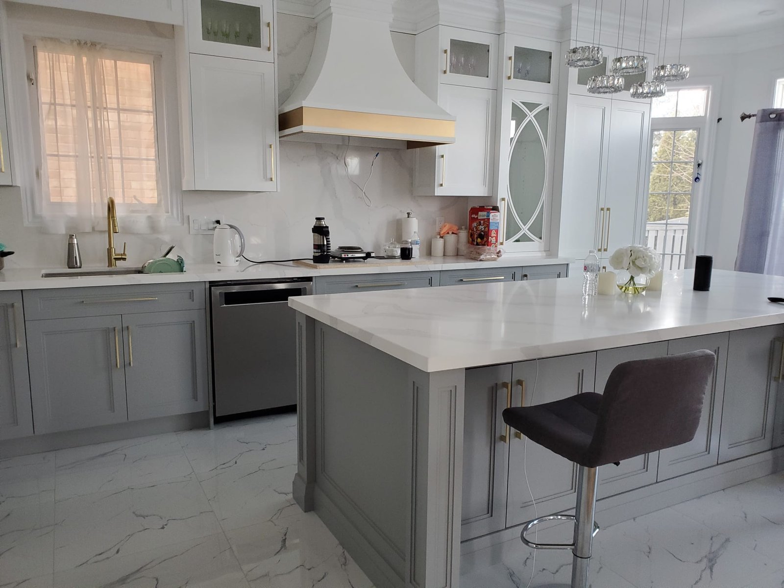 Gray kitchen island with quartz countertop and bar stools