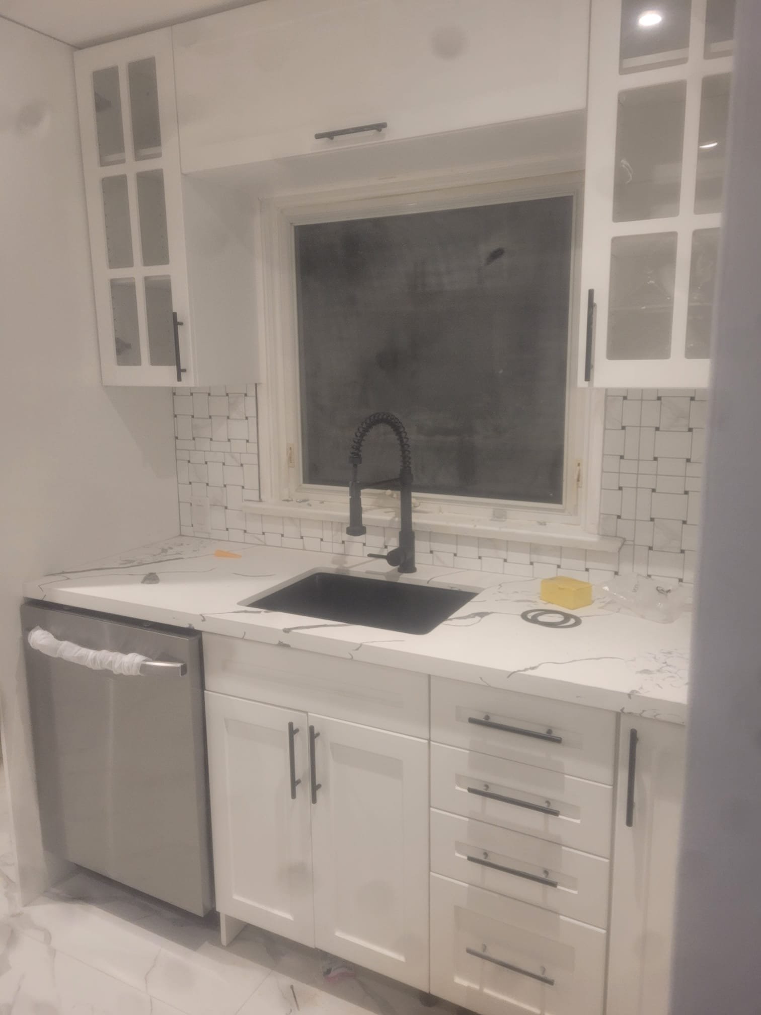 White shaker cabinets with quartz countertops and black farmhouse sink