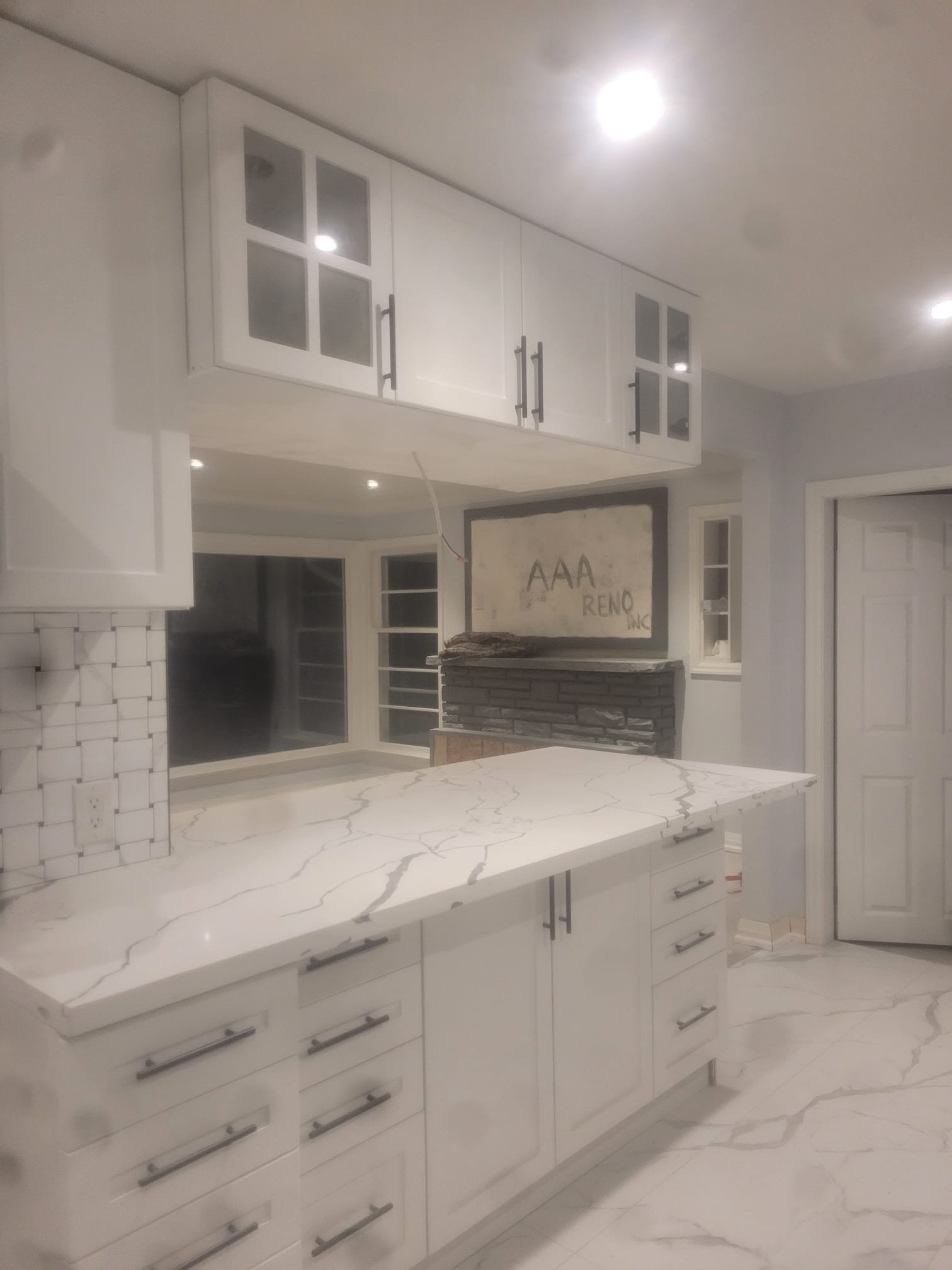 White kitchen renovation with quartz island and modern appliances