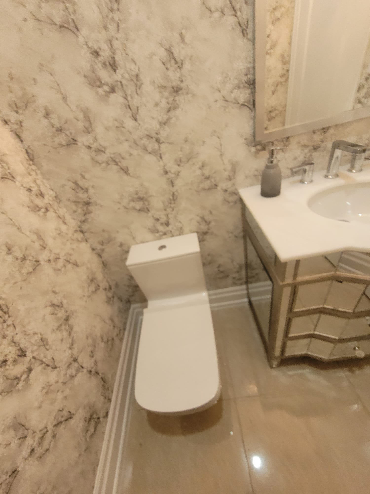 Elegant powder room with designer wallpaper and ornate vanity