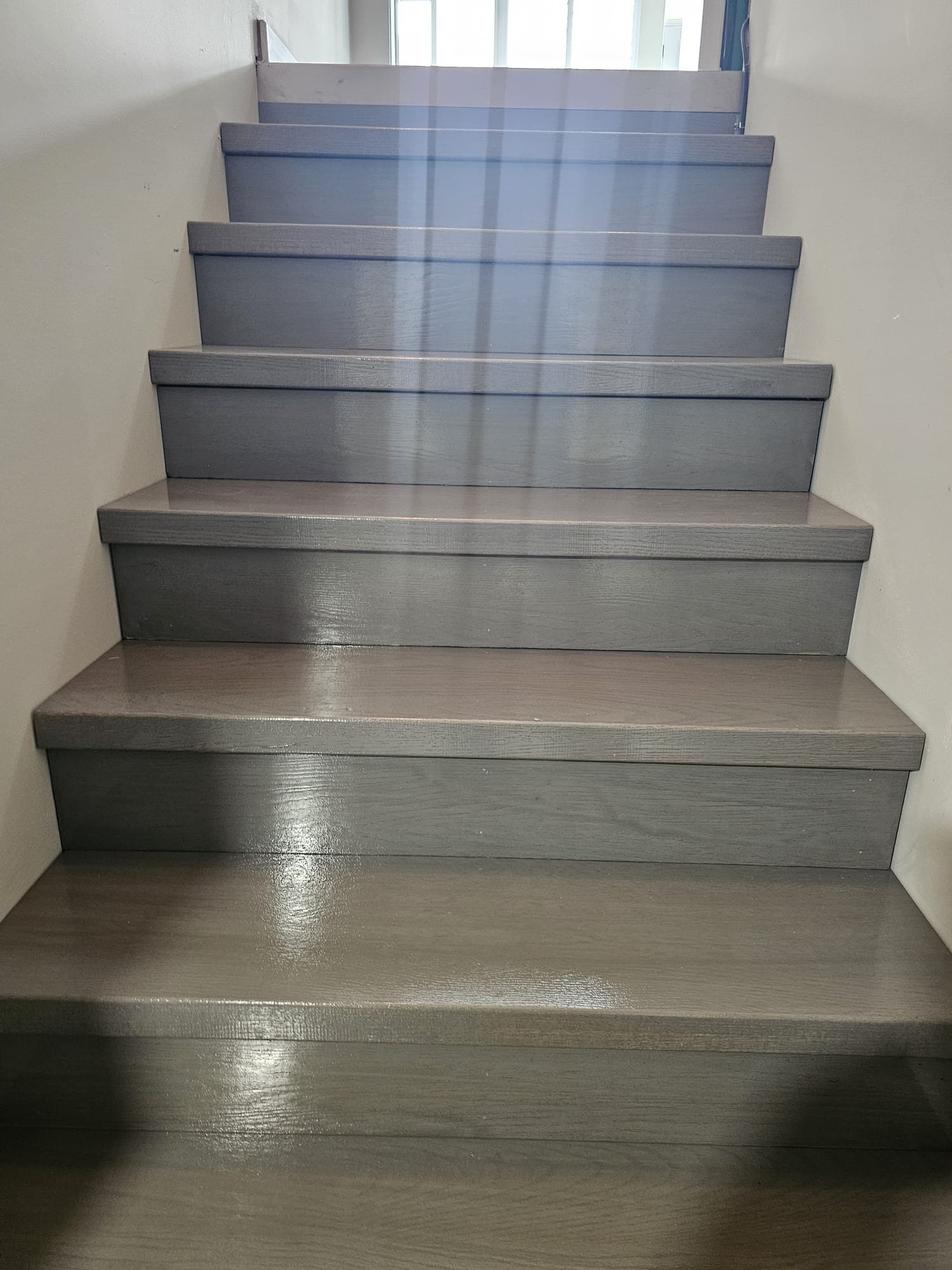 Gray laminate staircase installation with matching risers